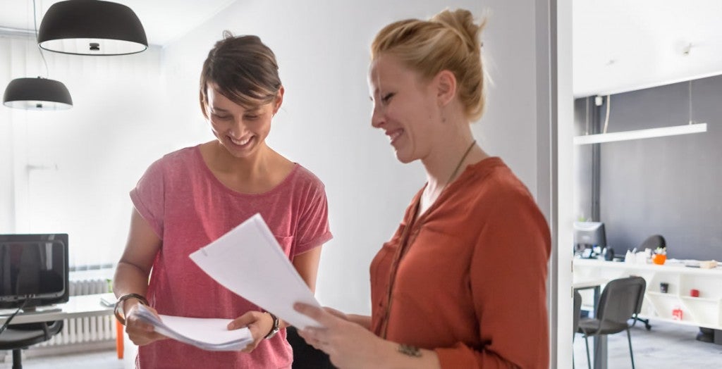 Duas mulheres conversam em um escritório. Após o diagnóstico da epilepsia é importante comunicar também no trabalho