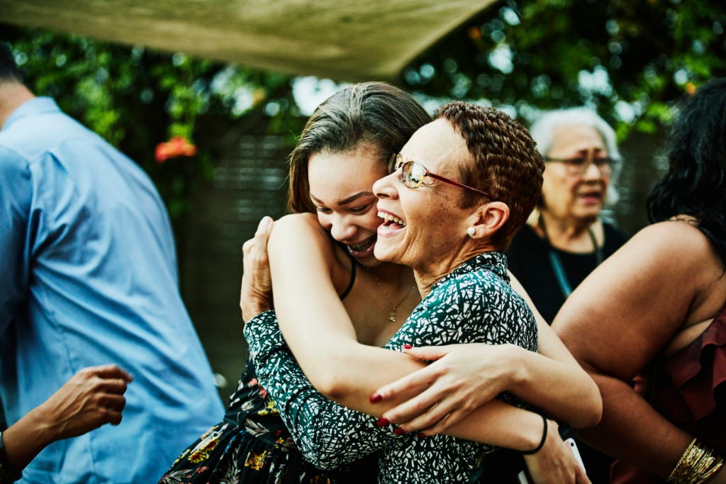 Duas mulheres se abraçam felizes em uma reunião de família.